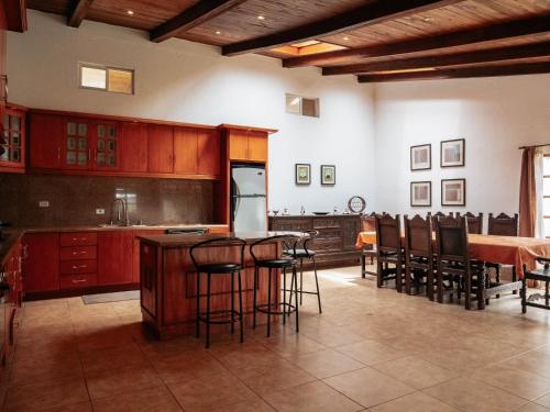 a kitchen with wooden cabinets and a table and chairs at La Quinta San Miguel-Located Between Two Volcanoes in Cotacachi