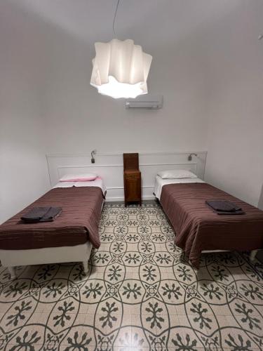 two beds sitting in a room with a floor at Casa del Poeta in Riva Ligure