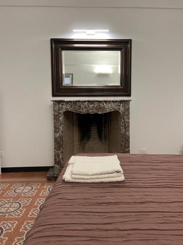 a room with a fireplace with a mirror above it at Casa del Poeta in Riva Ligure