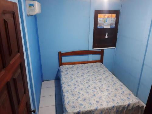 Dormitorio pequeño con cama pequeña en habitación azul en Cantinho da Jô, en Barra Grande