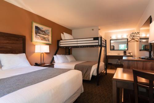 a hotel room with two beds and a desk at Riviera Motor Lodge in Saratoga
