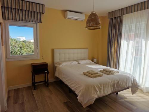 1 dormitorio con 1 cama con 2 toallas en Sherry Playa, en El Puerto de Santa María