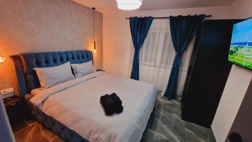 ein Schlafzimmer mit einem Bett mit einer schwarzen Tasche darauf in der Unterkunft Divine House Straja in Lupeni