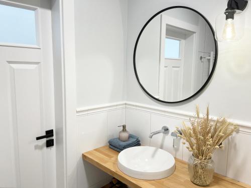 Un baño con un lavabo y un espejo en la pared. en Mari Vera, en Mielno