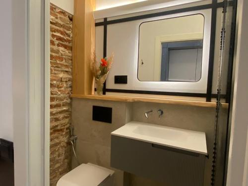W łazience znajduje się umywalka i lustro. w obiekcie APARTAMENTOS ALCALA w Madrycie