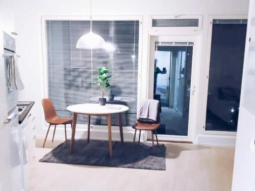 a dining room table with chairs and a potted plant at New Studio Mint near Airport in Vantaa