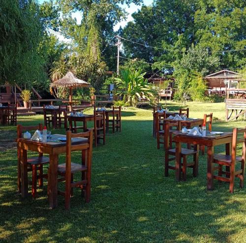 un groupe de tables et de chaises dans l'herbe dans l'établissement Cabañas Burdeos, à Tigre