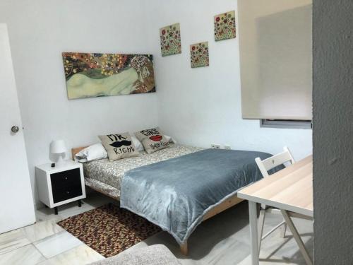 a small bedroom with a bed and a table at Tablada Los Remedios in Seville
