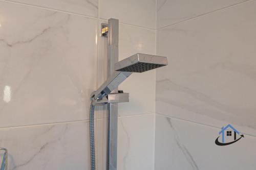 a shower in a bathroom with a shower head at Franklin House 2 bed, king bed, parkingx2, workspace, wi-fi, corporates in Hardingstone