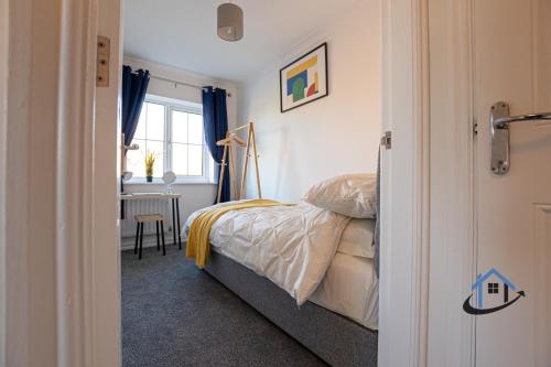 a bedroom with a bed and a desk and a window at Franklin House 2 bed, king bed, parkingx2, workspace, wi-fi, corporates in Hardingstone