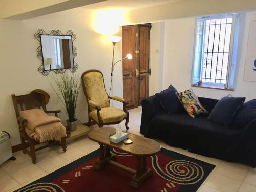 un salon avec un canapé et une chaise dans l'établissement Maison Ventenac village house, à Ventenac en Minervois
