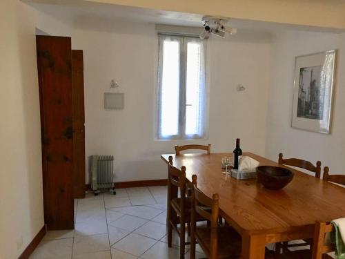 une salle à manger avec une table en bois et une fenêtre dans l'établissement Maison Ventenac village house, à Ventenac en Minervois