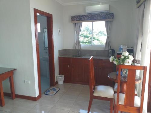 a kitchen with a sink and a table and a window at Ocean Breeze Resort in Toledo City