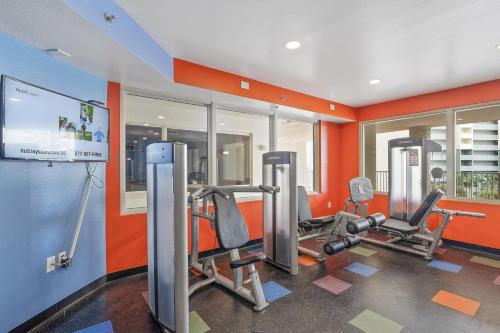 a gym with cardio equipment in a room with orange walls at Shores of Panama 1104 in Panama City Beach