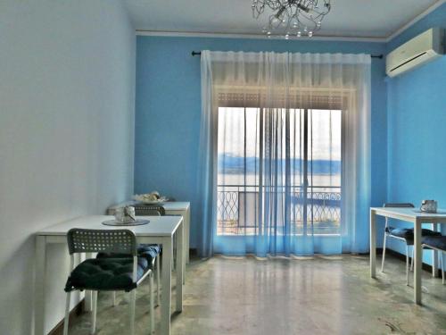 a blue room with a table and chairs and a window at La Feluca Rooms & Breakfast in Messina