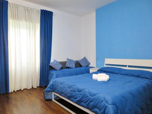 a blue bedroom with a bed and a couch at La Feluca Rooms & Breakfast in Messina