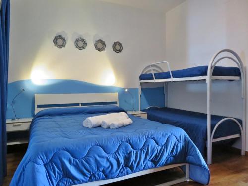 a bedroom with two bunk beds with blue sheets at La Feluca Rooms & Breakfast in Messina