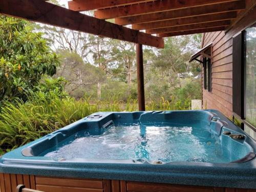 a jacuzzi tub sitting on the side of a house at Denmark Retreat by the river - Next to inlet & Bibbulmun Track with spa in Denmark