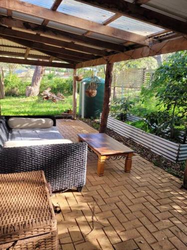 a patio with a wooden table and a bench at Denmark Retreat by the river - Next to inlet & Bibbulmun Track with spa in Denmark