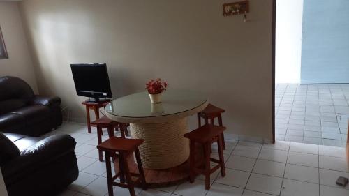 um quarto com uma mesa e cadeiras e uma televisão em Casa Adequadra para Home-Office. em Caruaru