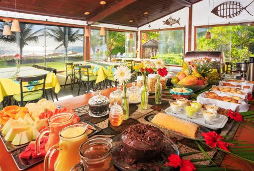 a long table with food and drinks on it at Pousada Canto do Porto in Porto De Galinhas