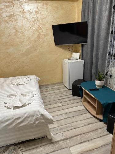 een slaapkamer met een bed en een flatscreen-tv bij Casa Geo Alex in Vaslui