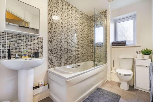 uma casa de banho com um lavatório, uma banheira e um WC. em Anox serviced apartment em Newcastle upon Tyne