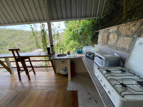 uma cozinha com um fogão e um balcão com um lavatório em Punta Hills Montanita em Montañita