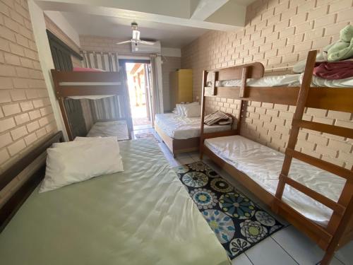 a dorm room with two bunk beds and a rug at Hotel Nelly in São Gabriel