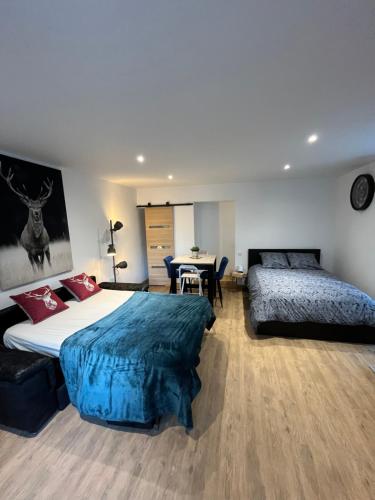 1 dormitorio con 2 camas y mesa en La croisée des chemins, en Le Bourg-dʼOisans