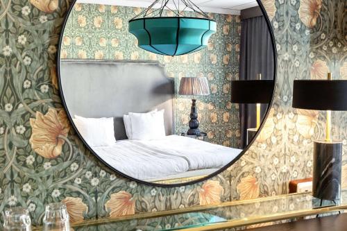 a bedroom with a mirror and a bed at Centric Hotel in Norrköping