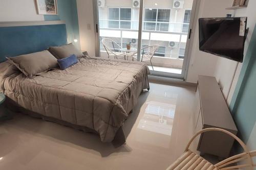 1 dormitorio con 1 cama, TV y ventana en Apart en San Telmo- Paseo de la Cisterna- 619 en Buenos Aires