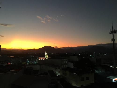a sunset over a city with mountains in the background at Vem pra cá! Localização Privilegiada! in Guarapari