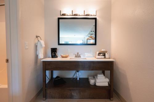 a bathroom with a sink and a mirror at Riviera Motor Lodge in Saratoga