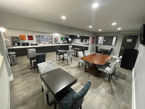a dining room with tables and chairs and a kitchen at Countryside Inn & Suites Omaha East-Council Bluffs IA in Council Bluffs