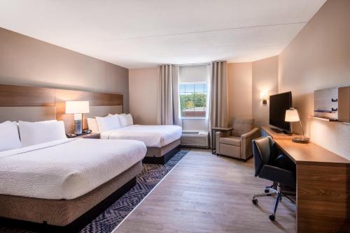Cette chambre comprend deux lits et un bureau. dans l'établissement Candlewood Suites Manassas, an IHG Hotel, à Manassas