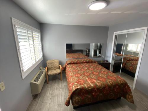 Schlafzimmer mit einem Bett, einem Schreibtisch und einem Fenster in der Unterkunft Mesa Oasis Inn & Motel in Mesa
