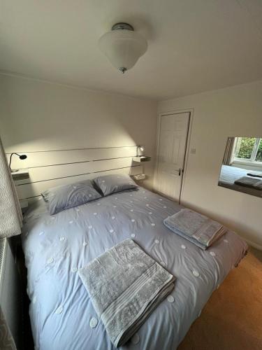 a bedroom with a bed with two towels on it at The Warren Holiday Park - Family Chalet in Abersoch