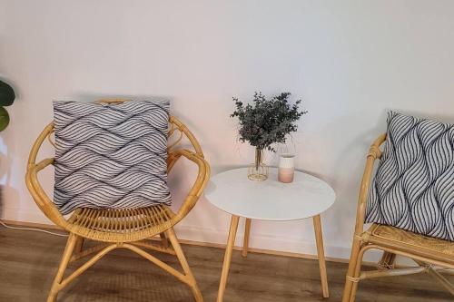 two chairs and a table with a vase on it at Stylish St. Kilda Apartment in Melbourne