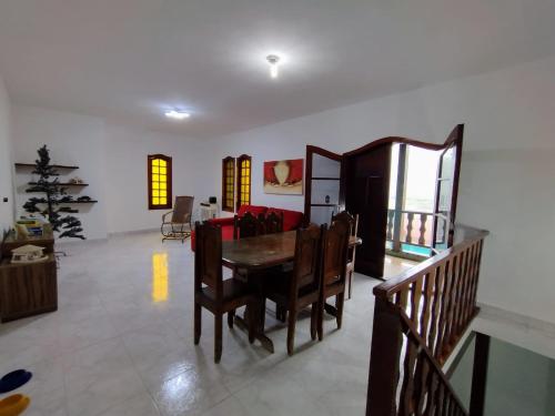 a living room with a table and a red couch at Casa em Miguel Pereira in Miguel Pereira