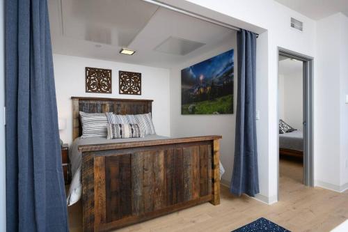 a bedroom with a wooden bed with blue curtains at Stylish SoBo Condo - Steps to Main St in Bozeman