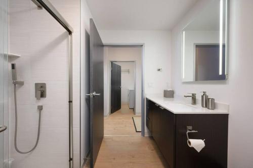 La salle de bains est pourvue d'une douche, d'un lavabo et d'un miroir. dans l'établissement Stylish SoBo Condo - Steps to Main St, à Bozeman