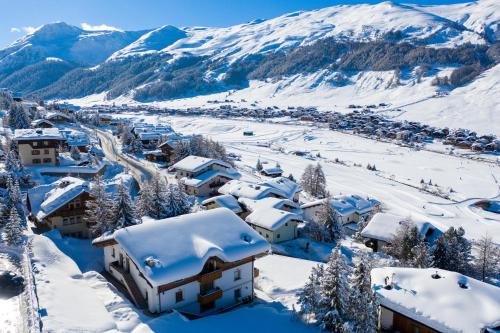 a village covered in snow with mountains in the background at Hotel Duc De Rohan in Livigno
