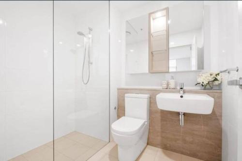 a bathroom with a toilet and a sink and a shower at Pool View of Marquarie Park Paradise in Sydney