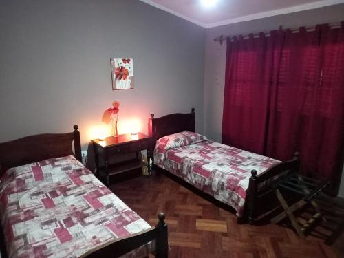 1 dormitorio con 2 camas y mesa con lámpara en Hospedaje en Salta