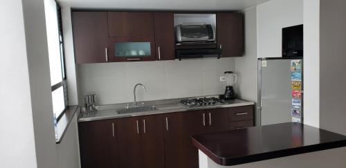 a small kitchen with a sink and a refrigerator at Apartamento La Floresta con todas las comodidades in Bogotá