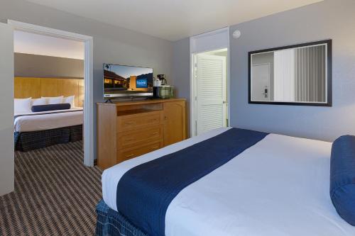a hotel room with a bed and a television at Travelodge by Wyndham Palm Springs in Palm Springs