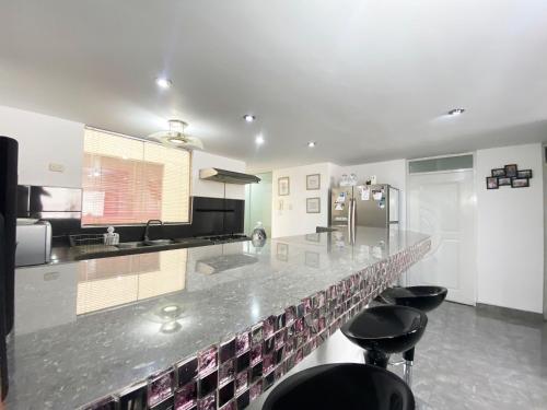a kitchen with a counter with stools in it at Ayli Apart Hotel in Arequipa