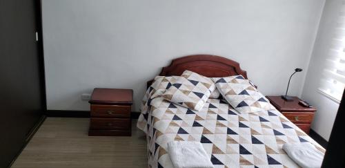 a bed with a quilt on it in a bedroom at Apartamento La Floresta con todas las comodidades in Bogotá