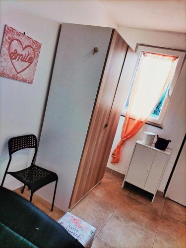 sala de estar con silla y ventana en Mini liquirizia e menta en Reggio Emilia